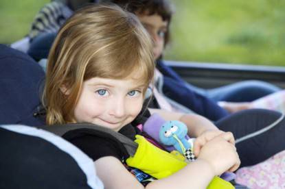 bambina sorridente sul seggiolino auto