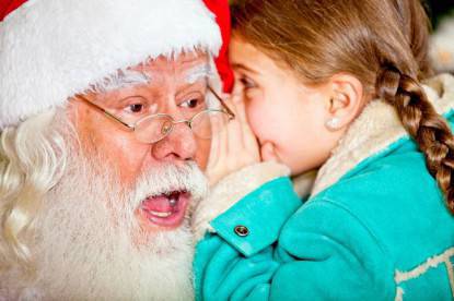 Bambina che racconta un segreto a Babbo Natale