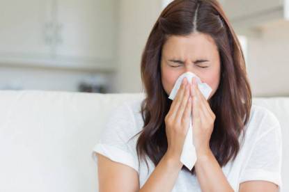 Donna con il raffreddore si soffia il naso (influenza)