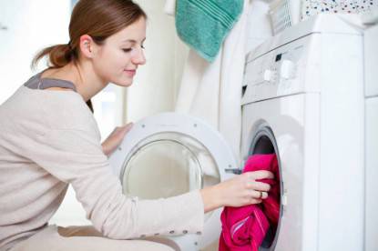Lavori di casa: giovane donna fa la lavatrice