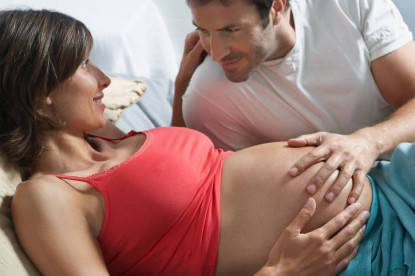 Uomo e donna incinta sul letto