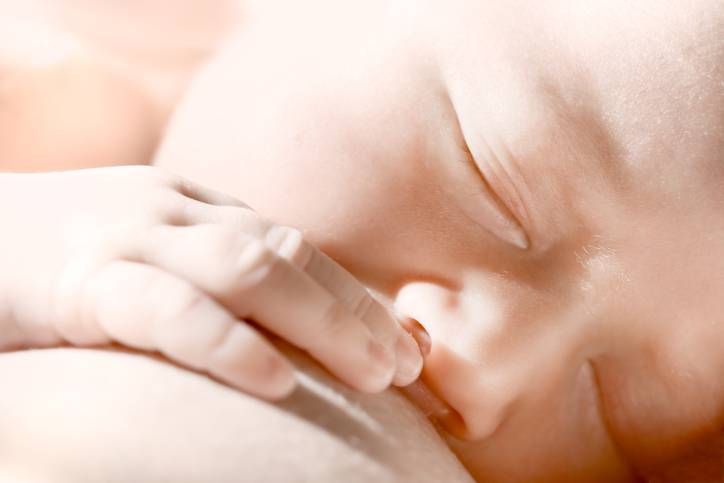 newborn baby eating breast-milk
