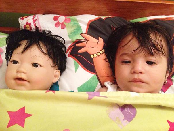 bambina e bambola a letto insieme