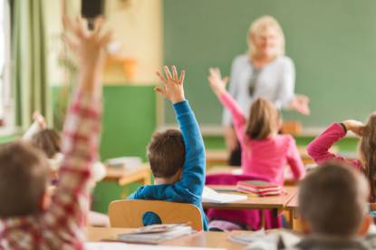 Rear view of school children ready to answer the question.