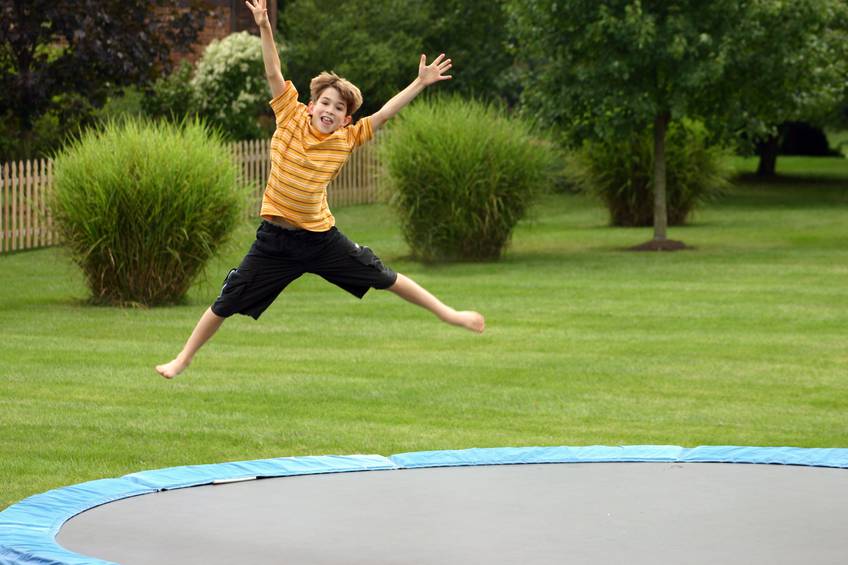A small child jumping on a trampoline