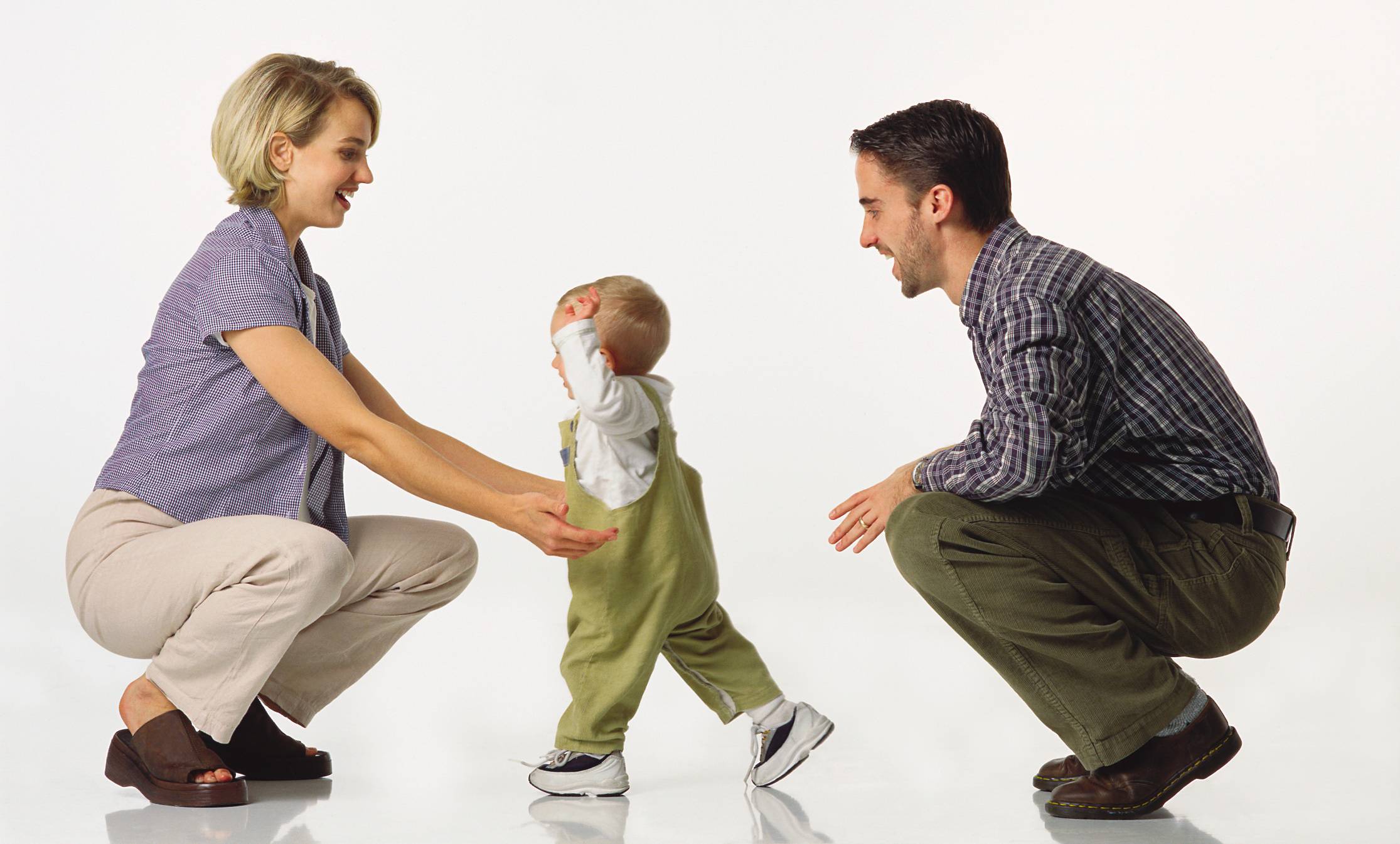 Bambino compie i suoi primi passi tra il papà e la mamma