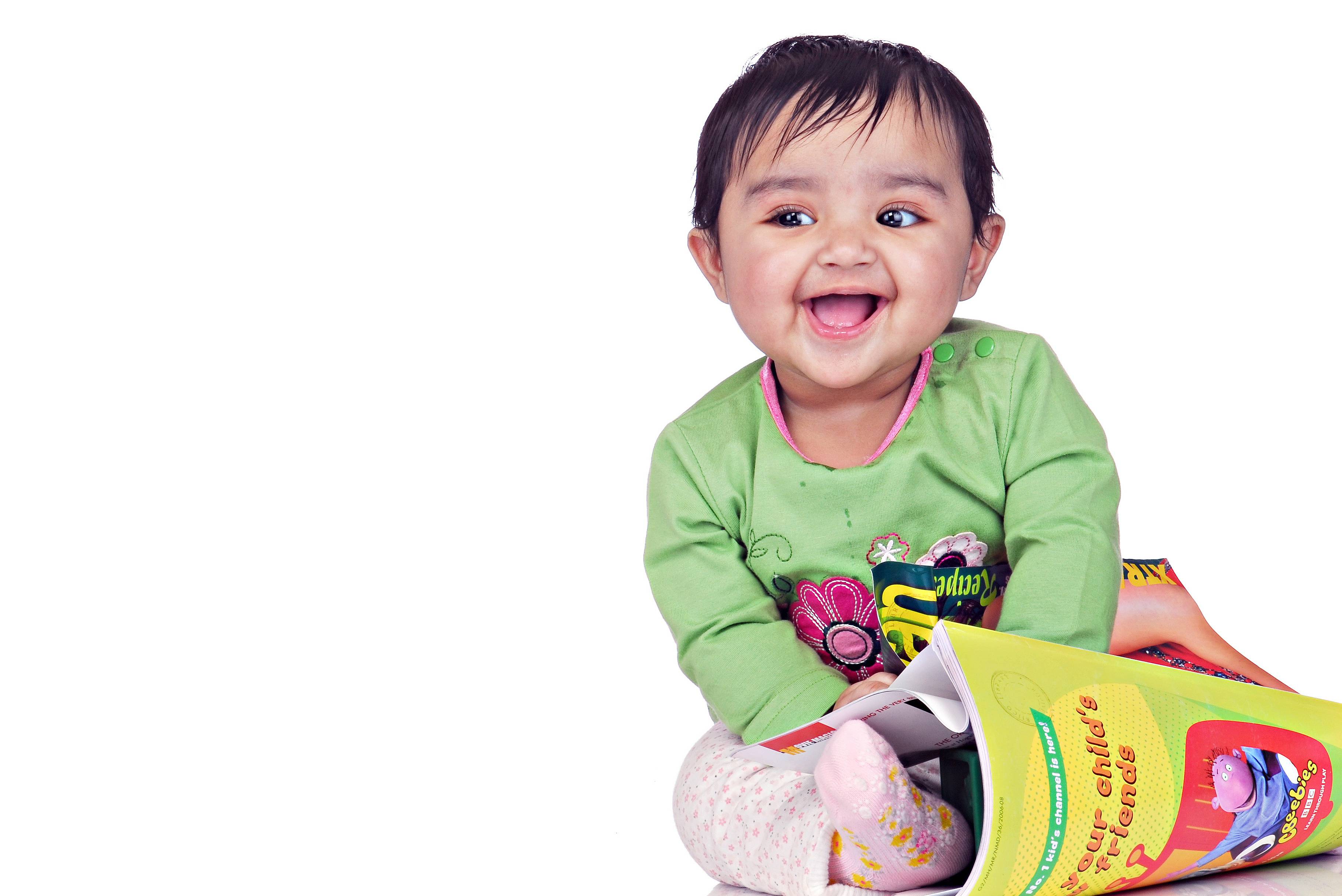 Bambina di 6-8 mesi sorridente con libro