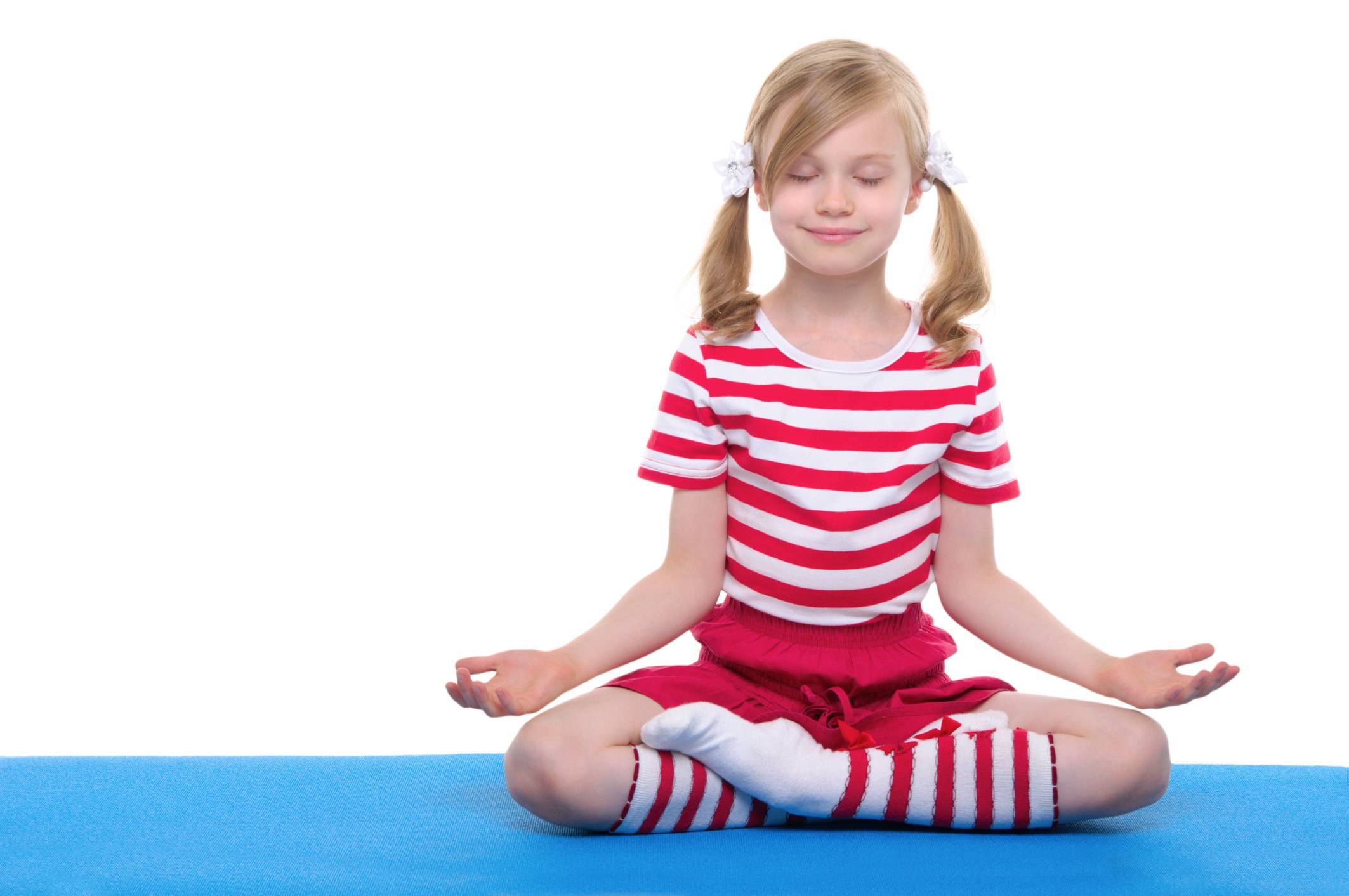 Bambina sorridente si rilassa in posizione yoga