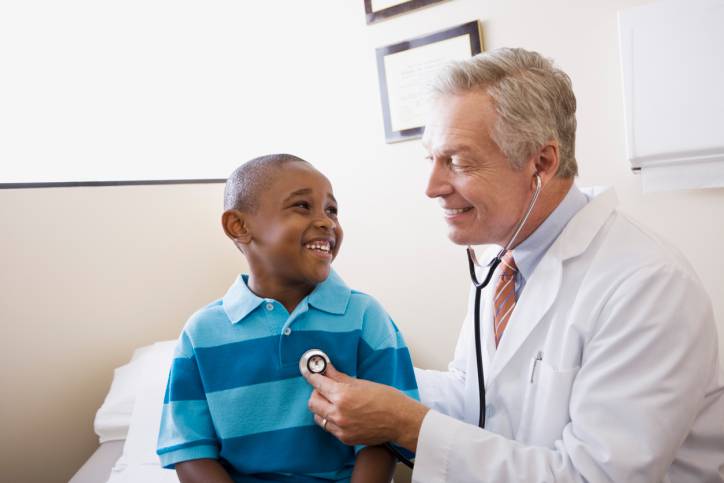 Dottore con lo stetoscopio che visita un bimbo