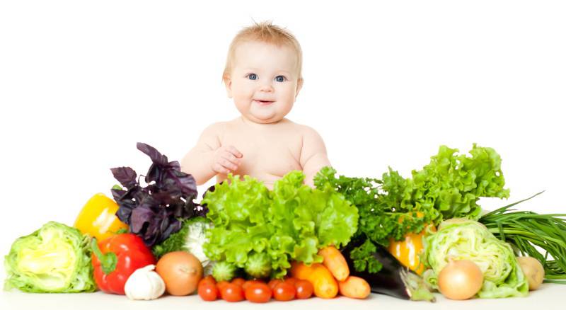 Bambino soridente tra verdura