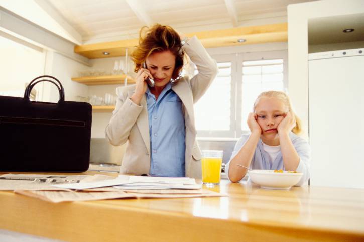 mamma stressata al telefono con bimbo accanto