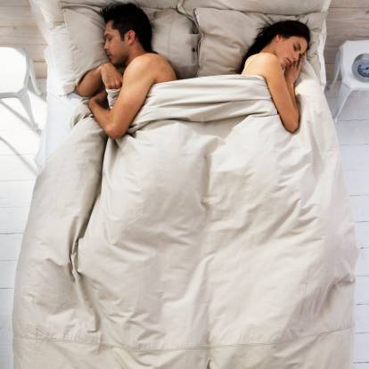 coppia che dorme ai lati opposti del letto