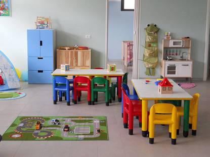 La stanza di un asilo nido, con piccoli tavoli e sedioline colorate