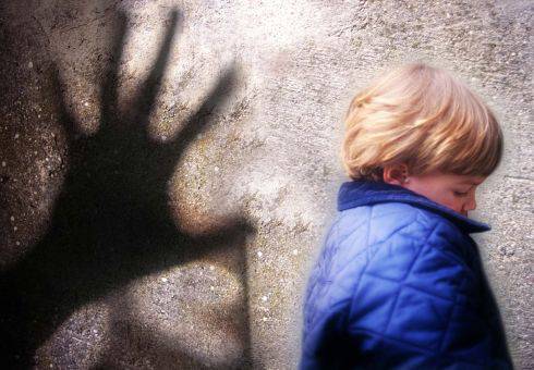 Bambino spaventato dalla presenza dell'ombra della mano di un uomo