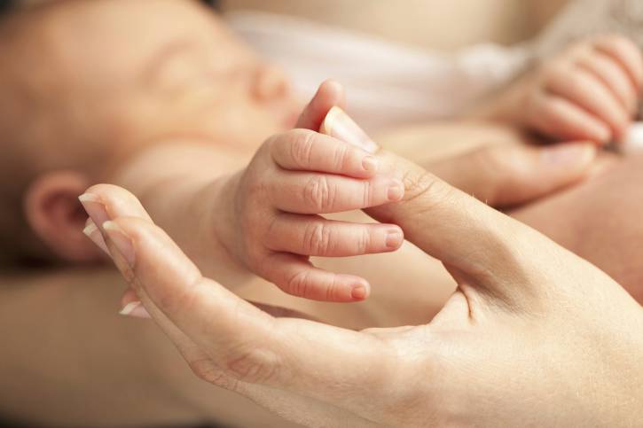 mano di neonato in mano di mamma