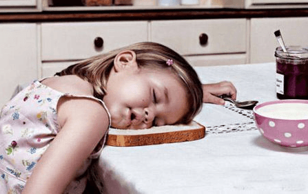 bambina addormentata sul tavolo della cucina