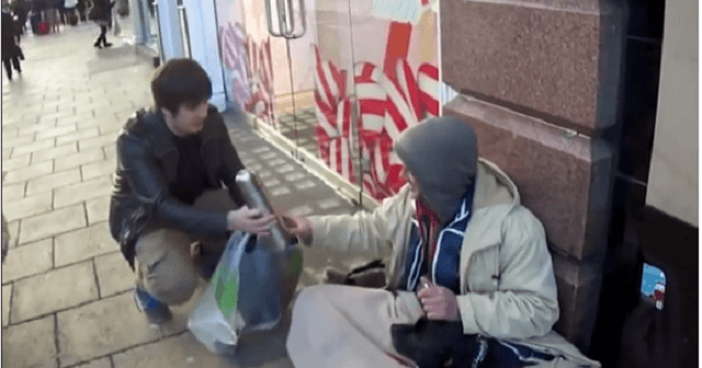 un ragazzo da cibo e vestiti a un barbone