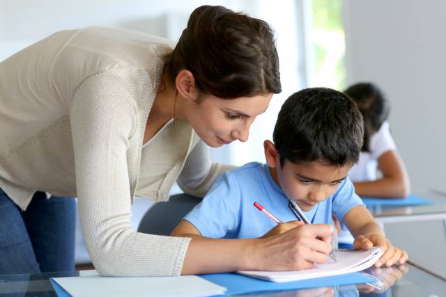 Una maestra spiega a un bambino