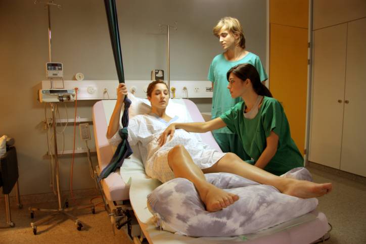Una donna in travaglio viene aiutata dalle ostetriche