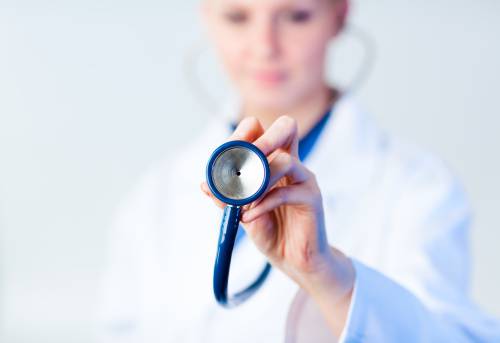 Doctor holding out stethescope with focus on object