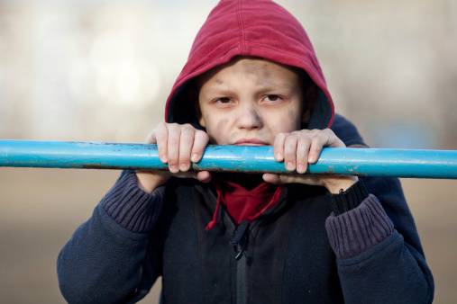 dramatic portrait of a little homeless boy