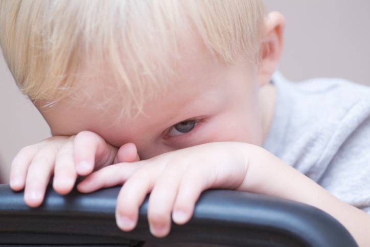 bambino che si nasconde dietro la sedia