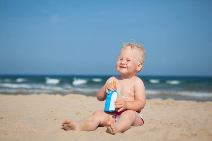 Fotoprotezione Adorable girl at beach applying sunblock cream Protezione solare