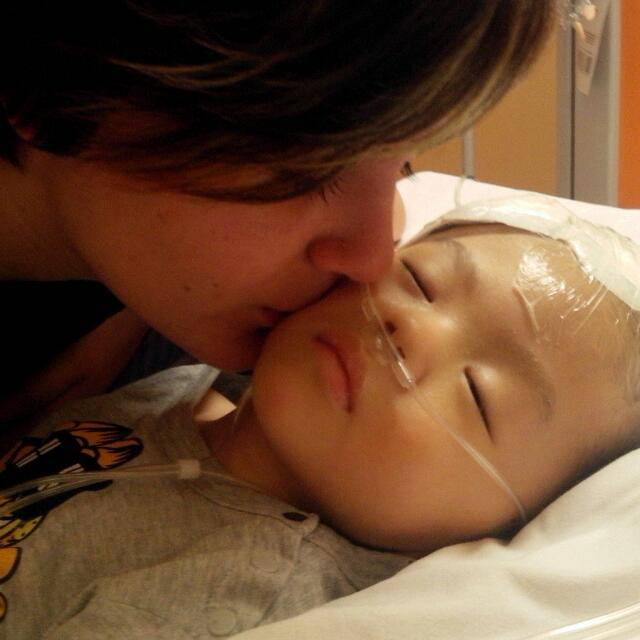 bambino malato baciato da una donna