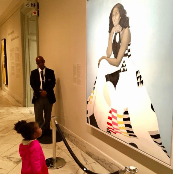 bambina guarda estasiata quadro michelle obama