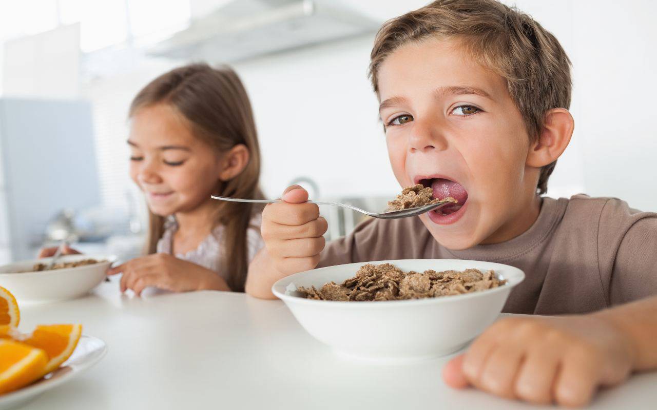 Bambini che mangiano i cereali