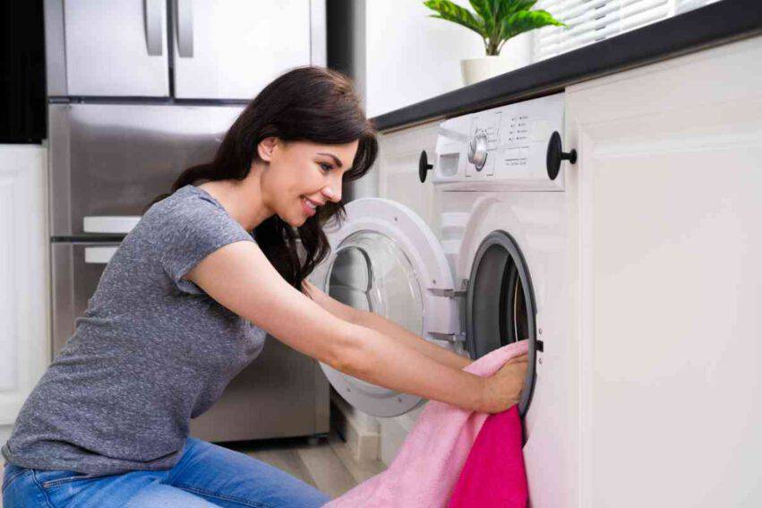donna che lava indumenti dei neonati in lavatrice