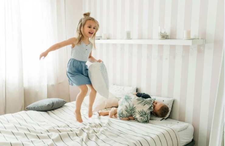 Bambina salta sul letto 