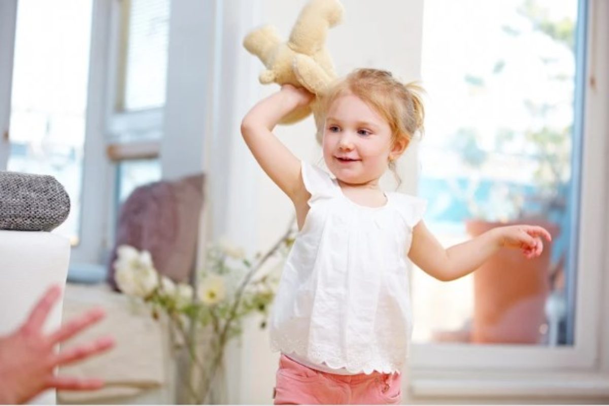 Bambina lancia un peluche