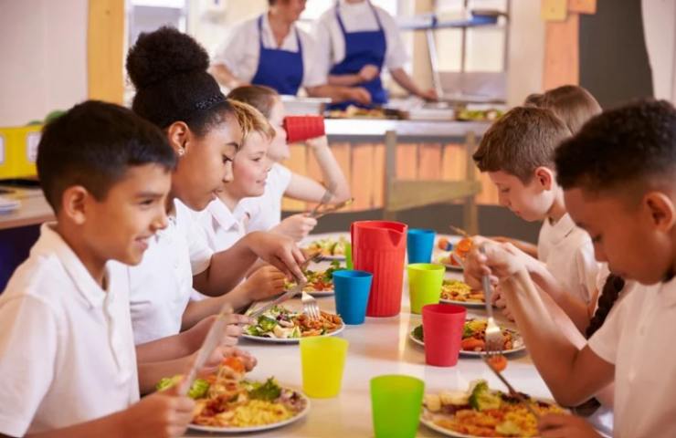bambini in mensa mangiano tutti insieme 