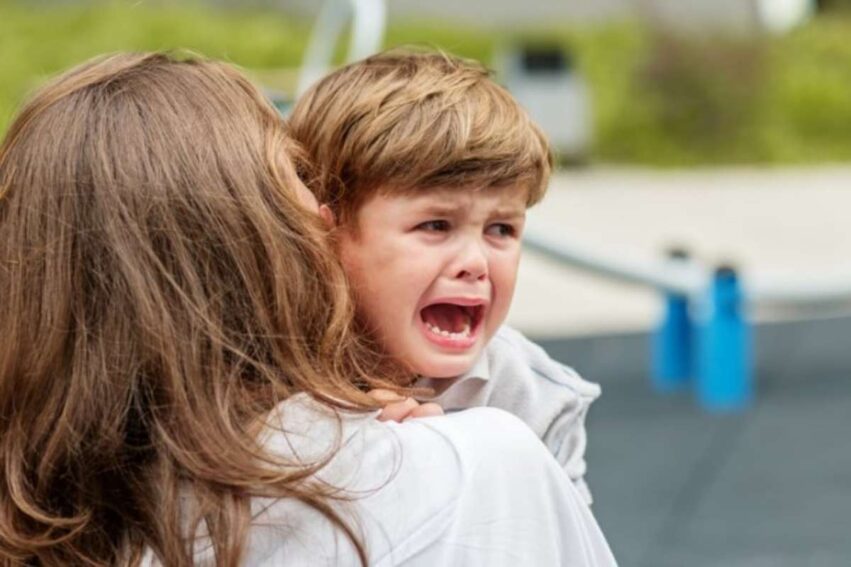 Bambino piange in braccio alla mamma