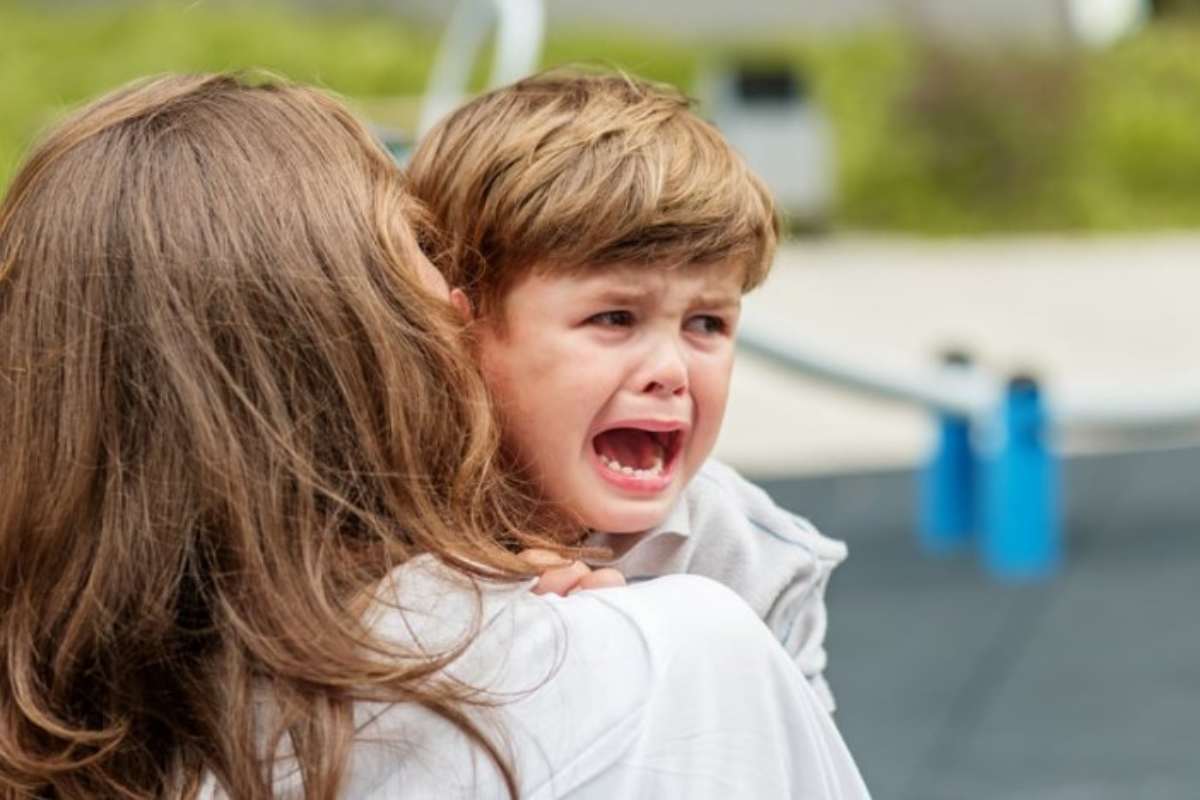 Bambino piange in braccio alla mamma