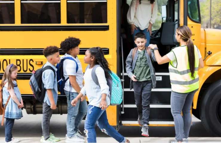 Bambini vanno a scuola con il pulmino