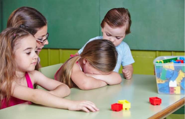 bambina piange sul banco di scuola 