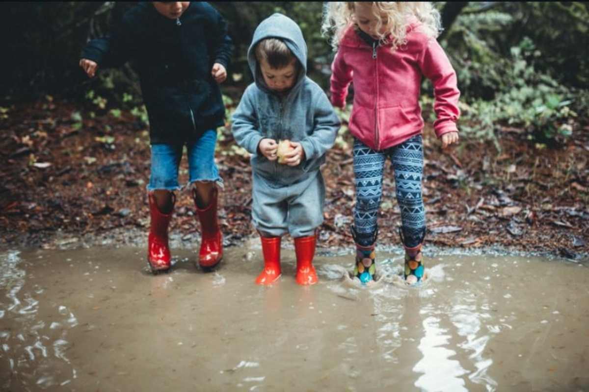 bambini giocano nelle pozzanghere dopo la pioggia