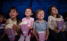 Bambini mangiano i popcorn al cinema