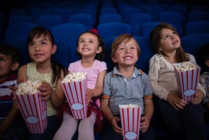 Bambini mangiano i popcorn al cinema