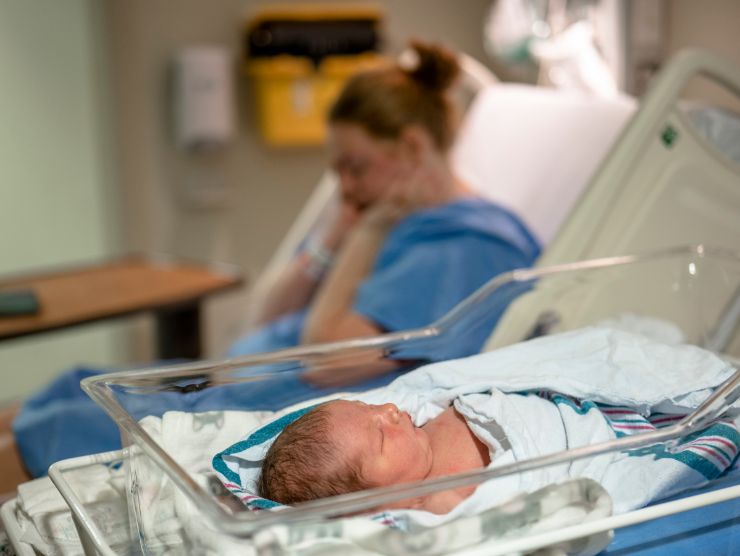 donna in un letto di ospedale che ha appena partorito